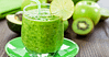 Πράσινο smoothie σερβιρισμένο σε ποτήρι με καλαμάκι και φέτα λάιμ