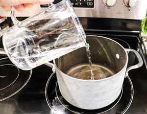 pouring water in pot to make kombucha tea