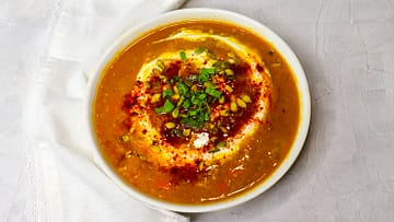 Orange soup topped with greek yogurt, pumpkin seed, and paprika,