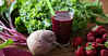 Purple smoothie served in a glass and the beet on the side