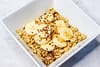 Oatmeal served in a white bowl, and topped with banana slices and peanut butter