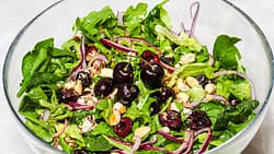 cherry gorgonzola salad served in a glass bowl with some cherries on the top