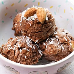 Nicecream served in a colorful bowl, and topped with almonds and coconut flakes