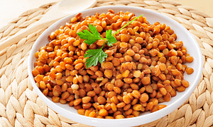 White bowl full of brown lentils