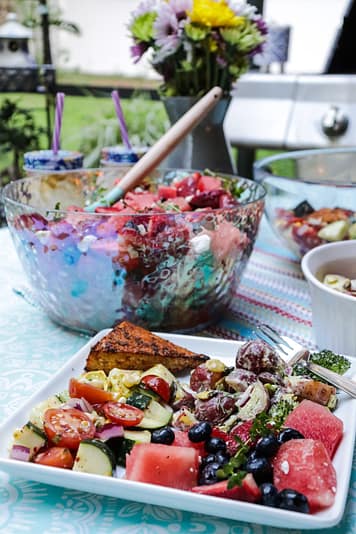 three summer salads berry potato, cajun chicken served on the table