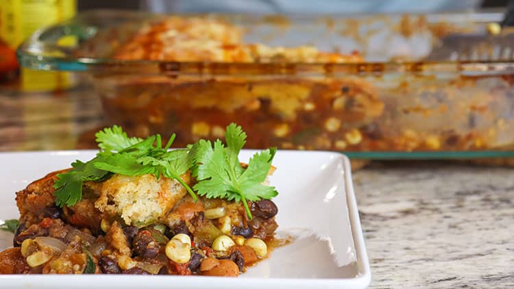 vegetarian fajita Mexican cornbread casserole served on a white plate and topped with fresh parsley