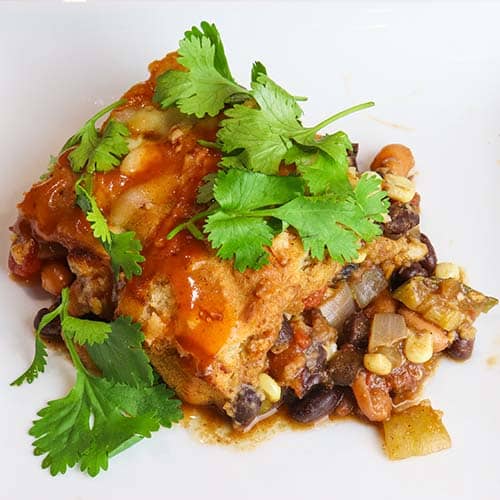 vegetarian fajita Mexican cornbread casserole served on a white plate and topped with fresh parsley