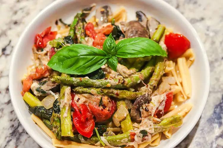 Pasta with veggies served in a white plate