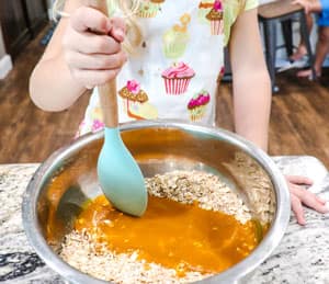 mixing pumpkin maple syrup mixture with oats and other dry ingredients