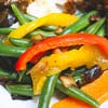 green beans with caramelized onions and peppers served on the white plate