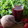Purple smoothie served in a glass and the beet on the side