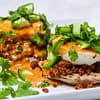 mexican eggs benedict with tofu chorizo chipotle hollaindaise served in a white plate