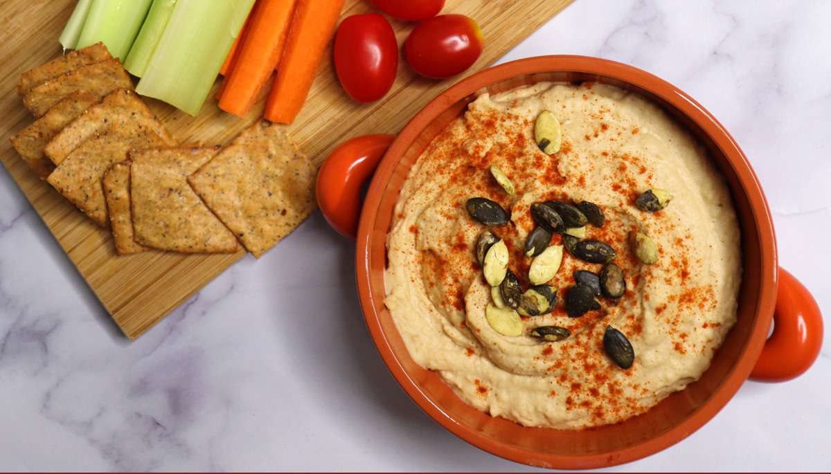 Hummus and carrots and tomatoes with some crackers on the side