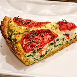 Slice of Tuscan Quiche with Garbanzo Bean Crust served in the white plate