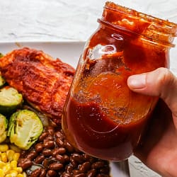 hand holding a jar full of hickory smoked bbq sauce