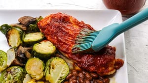 hickory smoked bbq sauce on top of a piece of meat, and some Brussel sprouts on the side