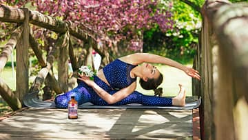 woman doing yoga with kombucha