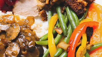 green beans with caramelized onions and peppers served on the white plate