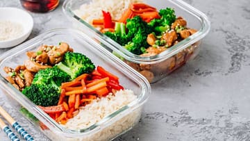 two glass bowls filled with rice,carrots,brocolli