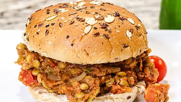 Instant Pot Lentil served in the bun on the white plate with some green paprika on the side