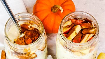two jars full of overnight oats and pumpkin on the side