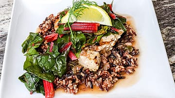Swordfish served on top of the brown rice, with some greens and piece of lemon