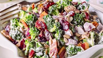 nice white bowl filled with broccoli and other vegetables overflowed with greek yogurt