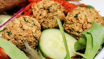 air fryer falafel nestled in a bed of salad in a gyro