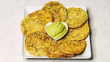 fried green tomatoes served on a white plate with some guacamole in small white bowl