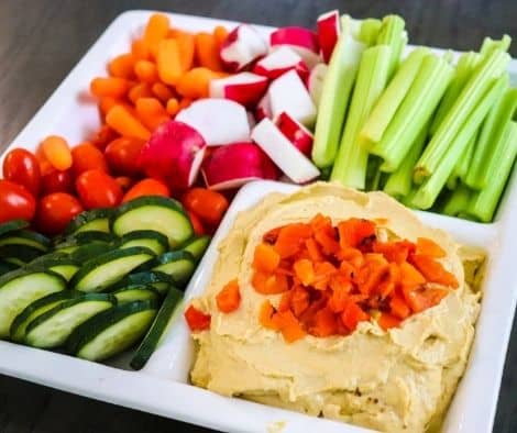 veggies and humus served in the white plate