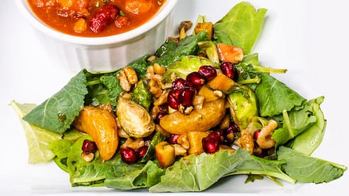winter harvest salad served on a leaf of a green salad