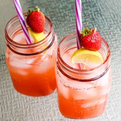 Looking down into strawberry detox lemonade with a strawberry and lemon garnish