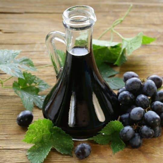 balsamic vinegar in a nice glass bottle and some grapes on the side