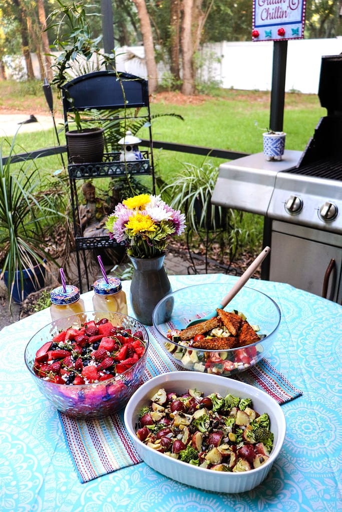 three vegan summer salads served on the table in the garden