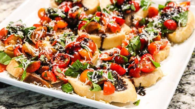Bruschetta served with balsamico and cherry tomatoes on the white plate