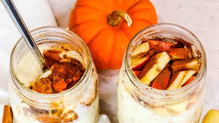 two jars full of overnight oats and pumpkin on the side