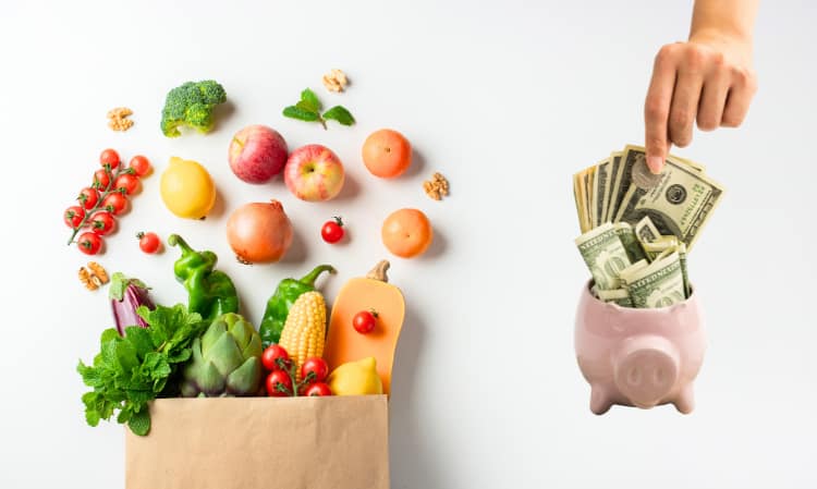healthy ingredients in a paper bag and a piggy bank full of money