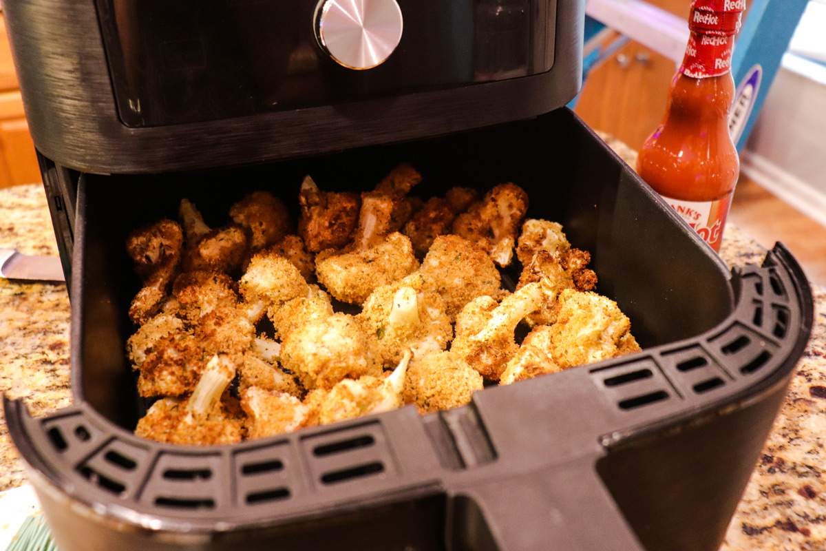 Crispy air fried cauliflower coming out of air fryer