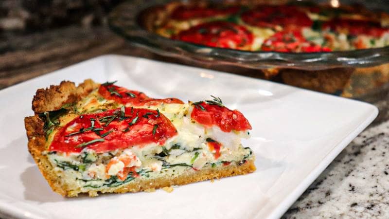 Slice of Tuscan Quiche with Garbanzo Bean Crust served on the white plate
