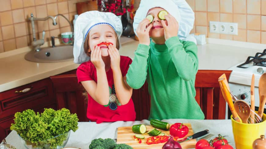 Kids playing with the vegetables in the kitchen