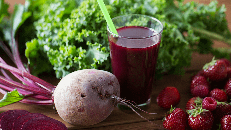 Purple smoothie served in a glass and the beet on the side