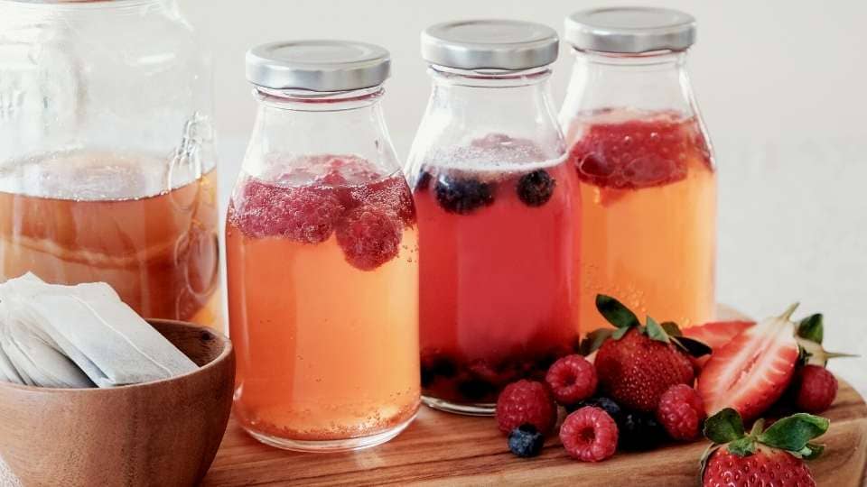 second fermentation of kombucha flavors,glass jars filled with raspberry, blueberry and strawberry kombucha